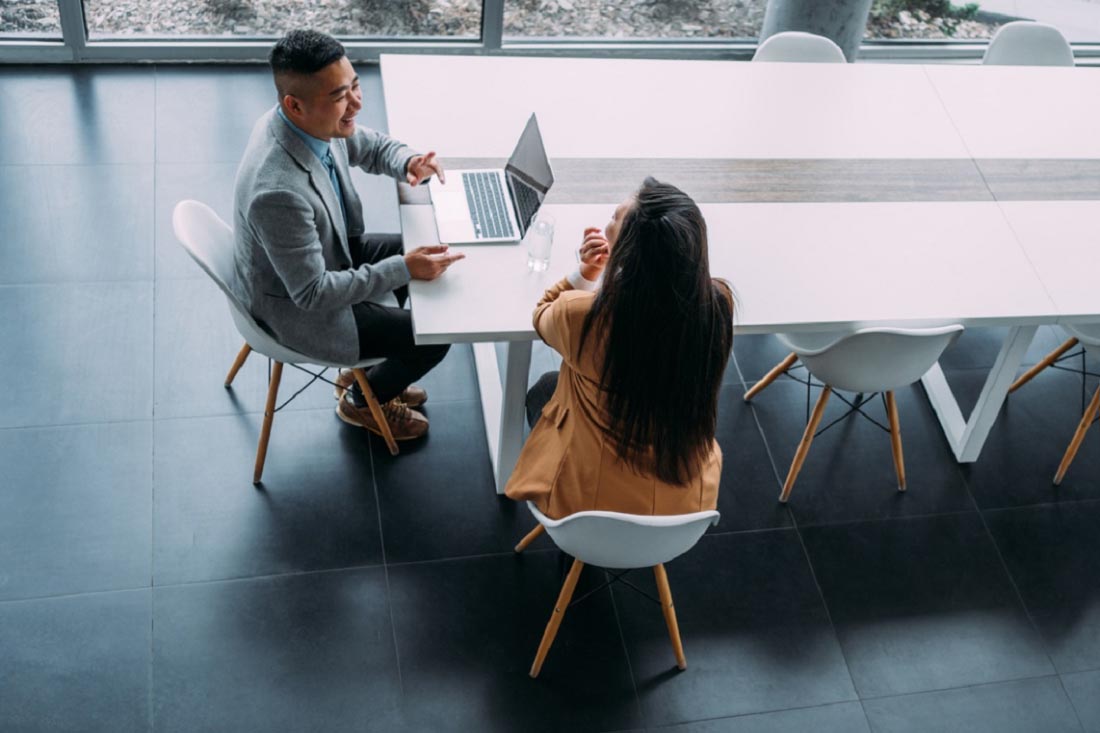 Two colleagues exchanging business productivity tips.