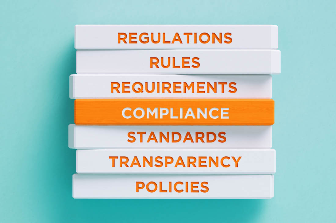 A stack of words related to compliance strategy.