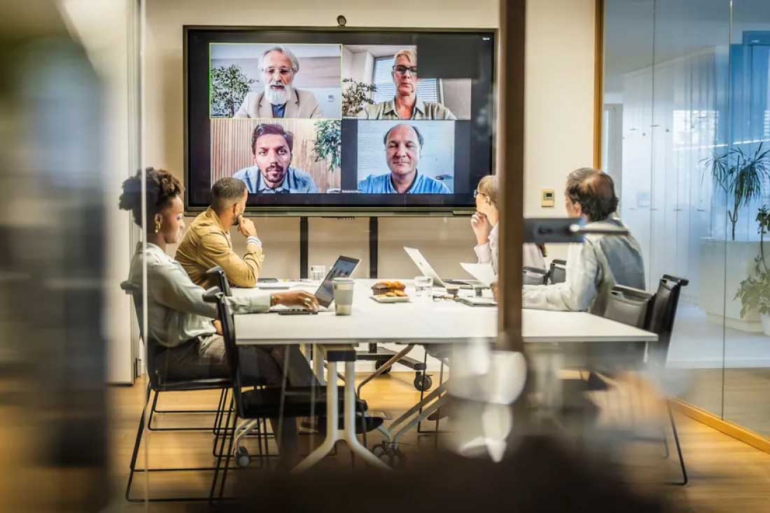 A hybrid team in a meeting using their hybrid workplace technology.