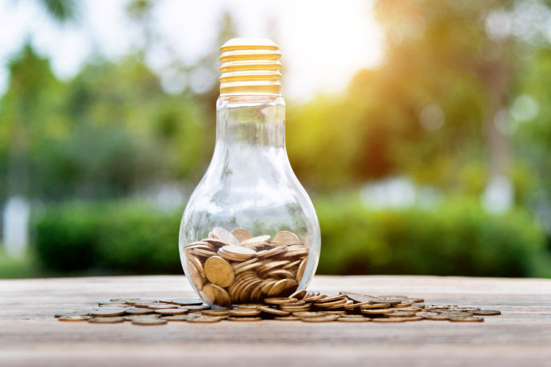 A light bulb with coins around it to signify cost saving ideas for large companies.